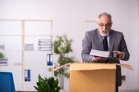 Old male employee in dismissal conceptの写真素材