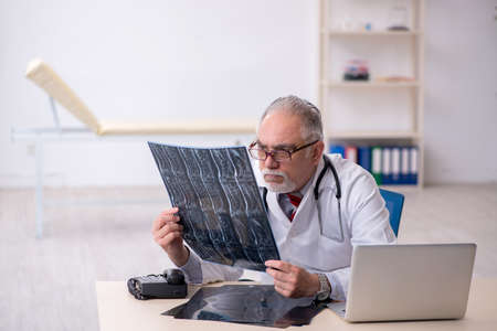 Old male doctor radiologist working in the clinicの写真素材