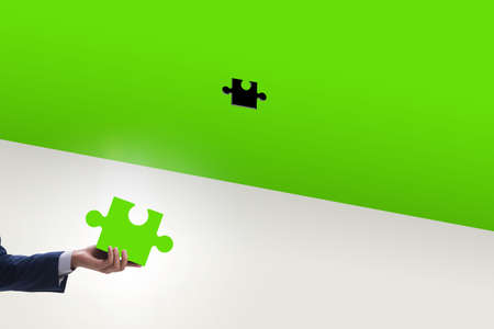 Businessman putting missing jigsaw puzzle pieceの写真素材