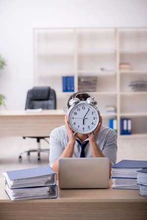 Young male employee in time management conceptの写真素材