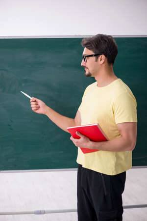 Young male student in front of blackboardの写真素材