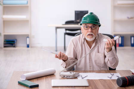 Old male architect working in the officeの写真素材