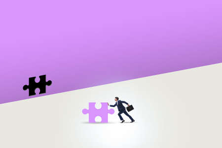 Businessman putting missing jigsaw puzzle pieceの写真素材