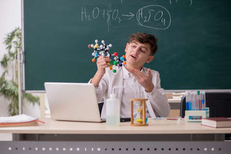 Schoolboy studying chemistry in the classroomの写真素材