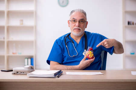 Old male doctor cardiologist working in the clinicの写真素材