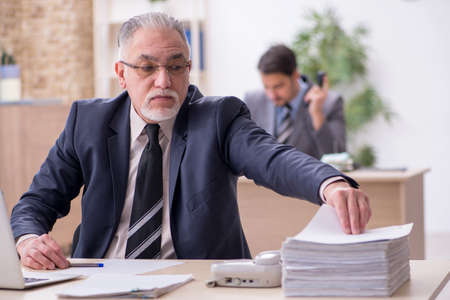 Two male employees working in the officeの写真素材