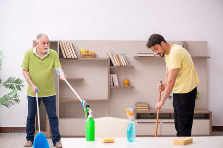 Two male contractors cleaning the houseの写真素材