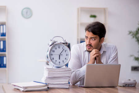 Young male employee in time management conceptの写真素材