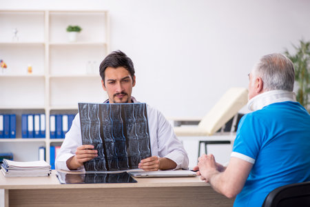 Old male patient visiting young male doctor radiologistの写真素材