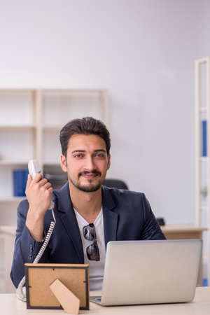 Young handsome employee working in the officeの写真素材
