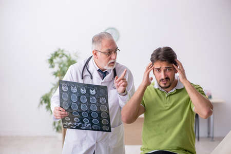 Young man visiting old male doctor radiologist