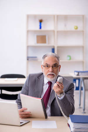 Old male employee working in the officeの写真素材