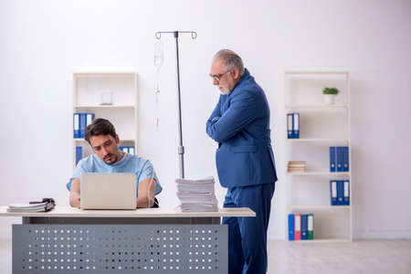 Young male employee feeling bad at workplaceの写真素材