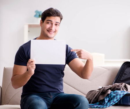 Man going on vacation packing his suitcaseの写真素材