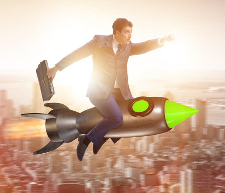 Male businessman flying on rocket in business conceptの写真素材