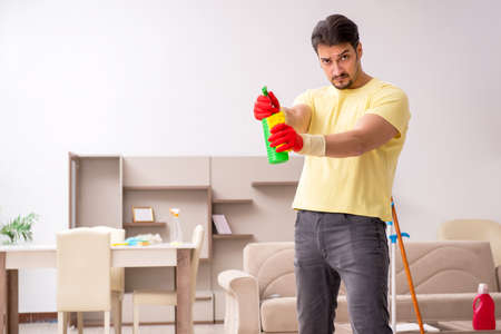 Young male contractor cleaning the houseの写真素材