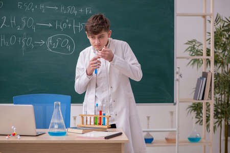 Schoolboy studying chemistry in the classroomの写真素材