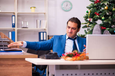 Young male employee working in the office at Chrismasの写真素材