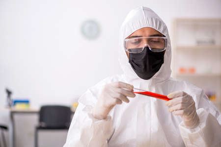 Young male chemist in drugs synthesis concept