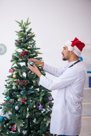Young male doctor celebrating Christmas at the hospitalの写真素材