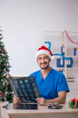 Young male doctor celebrating Christmas at the hospitalの写真素材