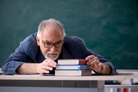 Old male teacher in the classroomの写真素材