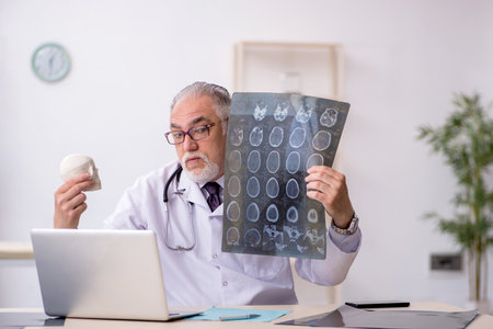 Old male doctor radiologist working at the hospitalの写真素材