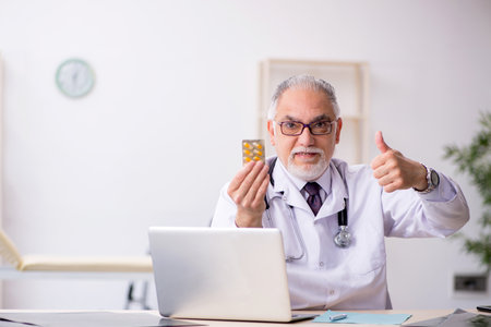 Old male doctor working at the hospitalの写真素材