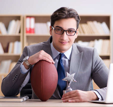 Businessman with american football in officeの写真素材