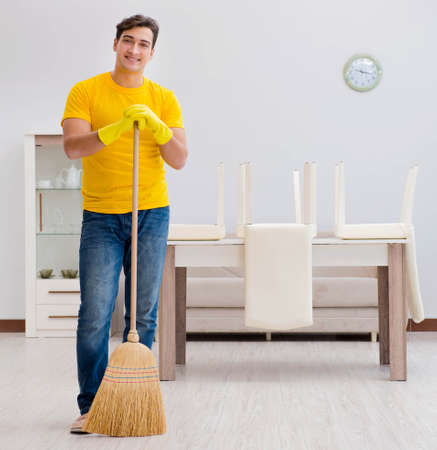 Man husband cleaning the house helping his wifeの写真素材