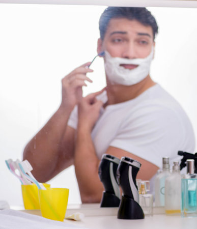 Young handsome man shaving in the morningの写真素材