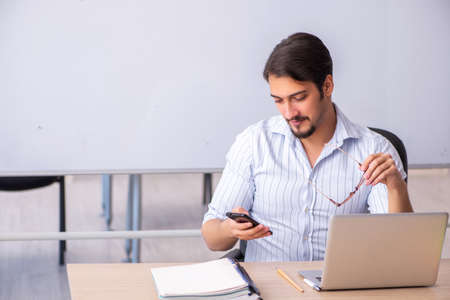 Young male teacher in front of whiteboard