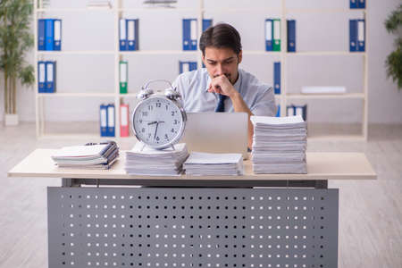 Young businessman employee unhappy with excessive work in the ofの写真素材