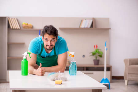 Young male contractor cleaning the houseの写真素材