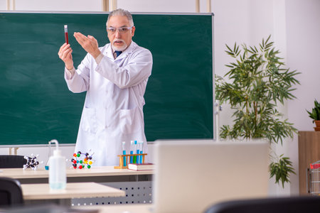 Old male teacher chemist in the classroomの写真素材