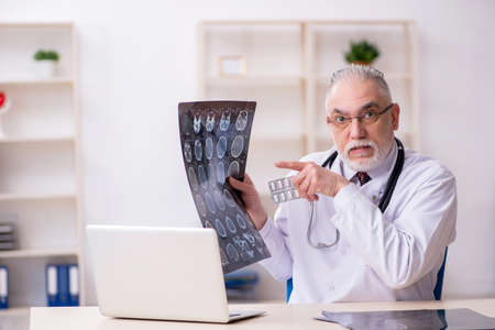 Old male doctor radiologist working in the clinicの写真素材