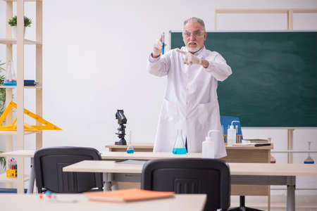 Old male chemist teacher in the classroomの写真素材