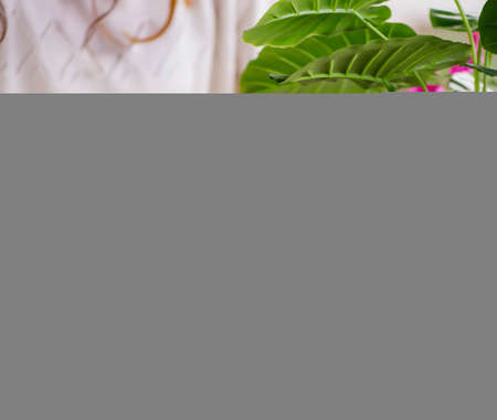 Young woman looking after plants at homeの写真素材