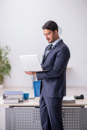 Young male employee sitting at workplaceの写真素材