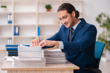 Young male employee unhappy with excessive workの写真素材