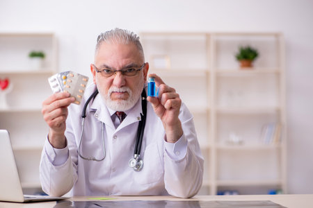 Old male doctor working in the clinicの写真素材