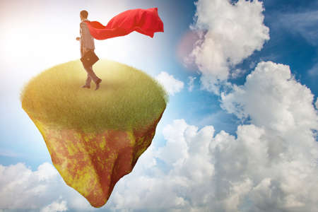 Businessman superhero on floating island in business conceptの写真素材