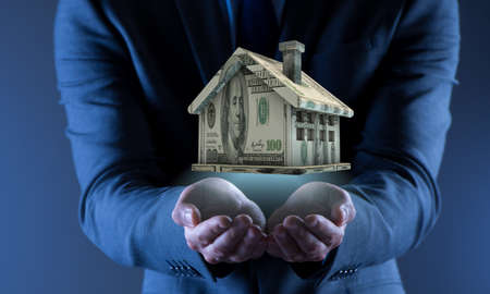 Young handsome businessman in mortgage conceptの写真素材