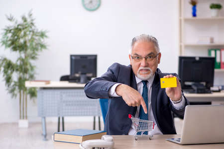 Old male employee in e-commerce conceptの写真素材