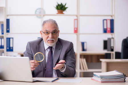 Old male auditor working in the officeの写真素材