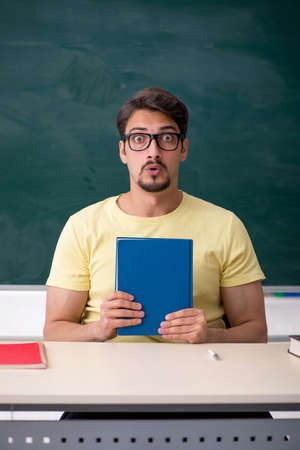 Young male student in front of blackboardの写真素材