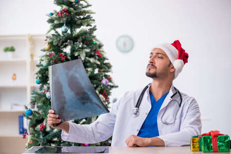Young male doctor celebrating Christmas at the hospitalの写真素材