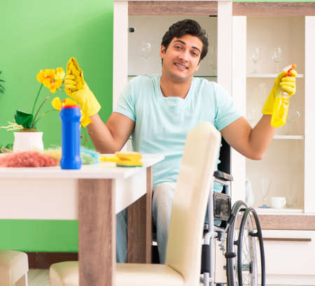 Disabled man on wheelchair cleaning houseの写真素材