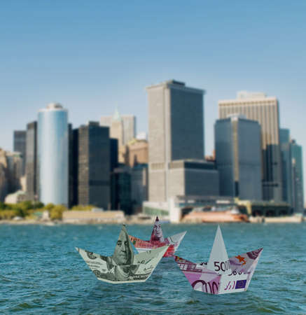 Euro and dollar boats against cityscape