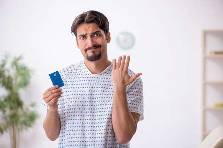 Young male patient holding credit cardの写真素材